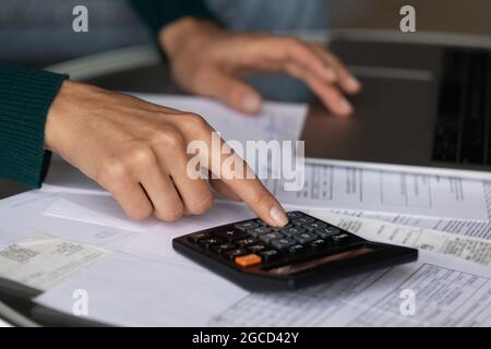 Primo piano donna utilizzando la calcolatrice, il controllo delle fatture nazionali, le finanze Foto Stock