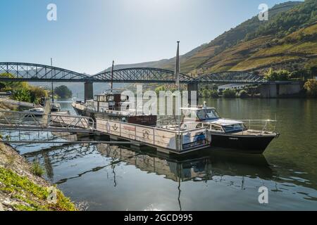 PINHAO, REGIONE DEL DOURO, PORTOGALLO - 22 OTTOBRE 2017: Barche parcheggiate presso il molo sul fiume Duoro nel villaggio di Pinhao, Portogallo Foto Stock