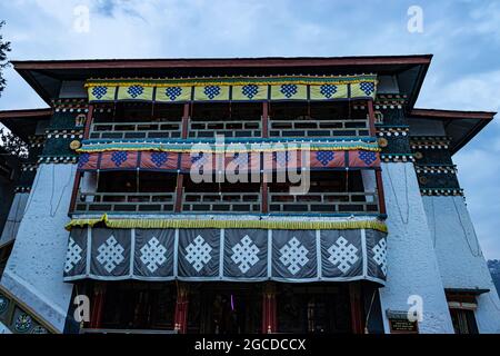 Il monastero buddista con bandiere religiose decorate al giorno da un'immagine ad angolo basso è preso al monastero di tawang arunachal pradesh india. Foto Stock