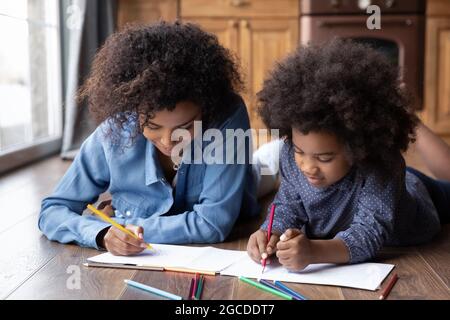 Felice disegno di mamma e figlia biraciale in album Foto Stock