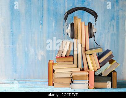 concetto di libro audio con un grande mucchio di libri e cuffie vintage, buon spazio di copia Foto Stock