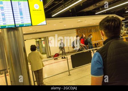 I passeggeri che indossano maschere arrivano all'aeroporto di Dublino, terminal 1, durante la pandemia di Covid19, Irlanda. Foto Stock