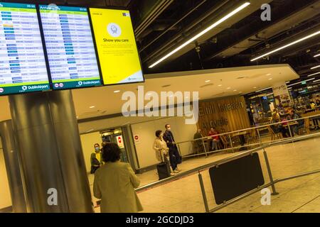 I passeggeri che indossano maschere arrivano all'aeroporto di Dublino, terminal 1, durante la pandemia di Covid19, Irlanda. Foto Stock