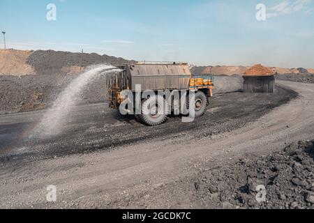 Macchina di irrigazione tagliata. Dumper da cava di grandi dimensioni. Grande dumper da miniera giallo sul luogo di lavoro. Produzione di minerali utili. Macchinari per l'estrazione di dumper da miniera a. Foto Stock