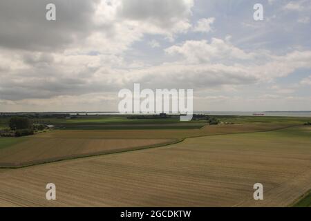 bella vista dei campi dietro il muro di mare del fiume scheldt sulla costa olandese in zeeland in primavera Foto Stock