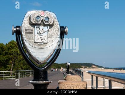 Una macchina binoculare a gettoni stazionaria che si affaccia ad ovest sulla passerella dei Sunken Meadow state Parks a Long Island New York. Foto Stock