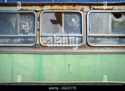 Abbandonato vecchio autobus da vicino, vista laterale. Modello vintage con vernice sbucciata e vetro rotto Foto Stock