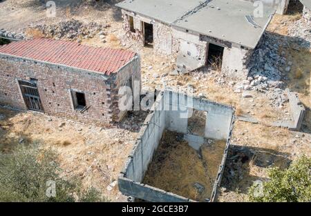 Rovine di vecchie case con muri rotti e tetto in villaggio abbandonato, vista dall'alto Foto Stock