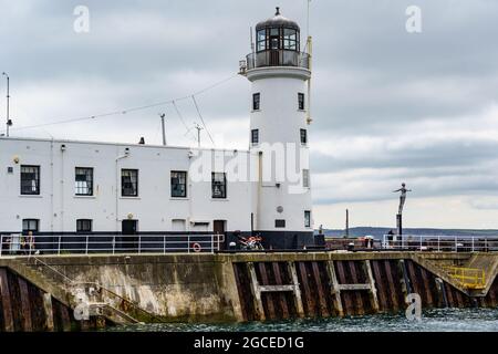 Faro bianco accanto alla scultura Diving Belle, Vincent Pier, The South Bay, Scarborough, North York, Inghilterra, Regno Unito. Foto Stock