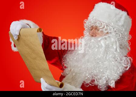 Babbo Natale con carta bianca marrone a scorrimento. Natale lista dei desideri concetto mockup Foto Stock