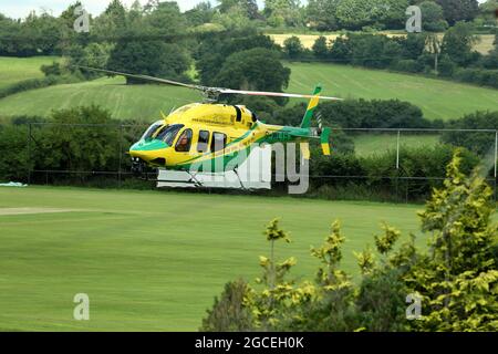 Wiltshire Air Ambulance subito dopo il decollo dal Purnells Cricket Club di Paulton, Somerset, Regno Unito Foto Stock