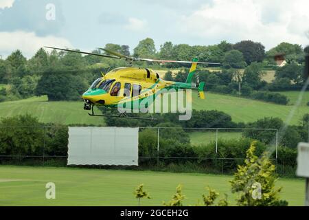 Wiltshire Air Ambulance subito dopo il decollo dal Purnells Cricket Club di Paulton, Somerset, Regno Unito Foto Stock