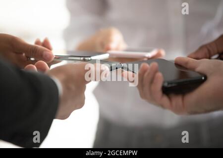 Un primo piano di persone diverse utilizza gli smartphone in cerchio Foto Stock