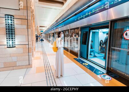 23 febbraio 2021, Dubai, Emirati Arabi Uniti: Donna asiatica che indossa una maschera protettiva che entra in treno della metropolitana a Dubai. Concetto di coronavirus e covid-19 pandem Foto Stock