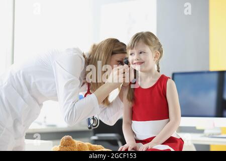 Il medico esamina le orecchie del bambino con un otoscopio nel closeup dell'ufficio del medico Foto Stock