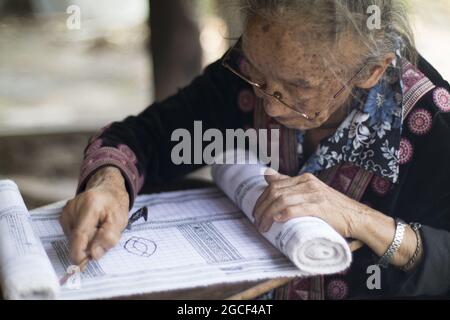 CHIANG RAI, THAILANDIA - 13 maggio 2019: Una donna anziana con bicchieri che fa artigianato tradizionale, vita in villaggio a Chiang Rai, Thailandia Foto Stock