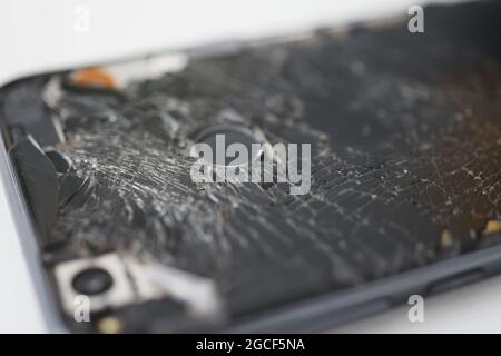 Smartphone nero su sfondo bianco rotto Foto Stock