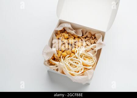 Spuntini di birra, commercio di consegna del cibo, antipasto salato croccante alla sera, covid-19. Delizioso set di arachidi, mais e formaggio in scatola eco cartone su whit Foto Stock