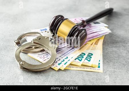 Banconote in euro, gavel giudice e manette sul tavolo arrugginito. Foto Stock