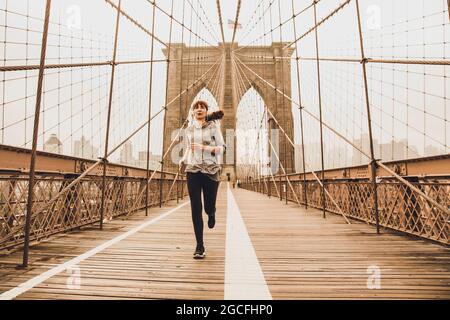 Donna che pratica jogging sul bridge5 Brooklyn Foto Stock