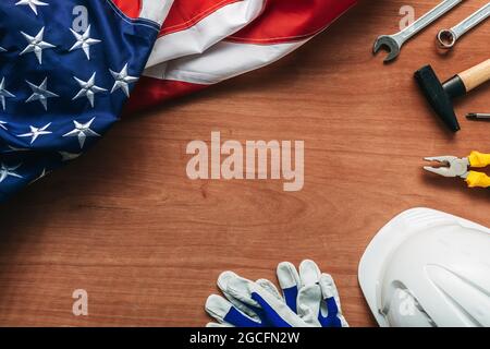 Concetto American Labor Day, vista dall'alto piatto con bandiera USA e utensili su scrivania in legno, direttamente sopra Foto Stock