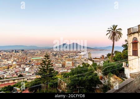 Napoli, Italia - 11 luglio 2021: Baia di Napoli e vulcano Vesuvio in background al tramonto in una giornata estiva in Italia, Campania Foto Stock