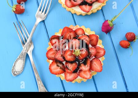 Piccola torta aperta con crema di mascarpone e fragole fresche decorate con sciroppo di liquirizia sopra la vista Foto Stock