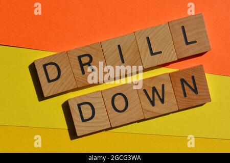Drill down, buzzword business in lettere alfabetiche in legno isolate su sfondo colorato Foto Stock