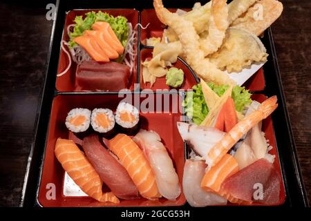 Messa a fuoco selettiva e vista dall'alto al Sushi Bento Box Set, contiene nigiri di salmone e tonno, panini, tempura e Sashimi. Foto Stock