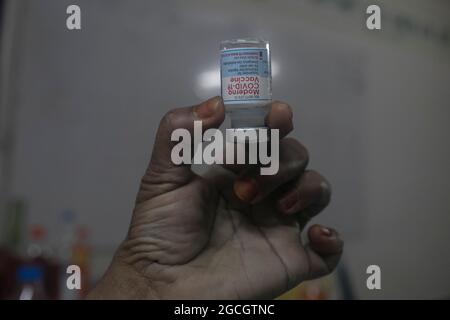 Dhaka, Bangladesh. 8 agosto 2021. Un operatore sanitario mostra la dose di vaccino moderna COVID19, durante una campagna di vaccinazione di massa in un centro di vaccinazione. Secondo la direzione Generale dei servizi sanitari del Bangladesh (DGHS), il programma nazionale di vaccinazione di massa, inizia la sua campagna di vaccinazione volta a immunizzare 3.5 milioni di persone in sei giorni. Il Bangladesh ha registrato quasi 1.31 milioni di infezioni da coronavirus e 21,638 decessi dall'inizio della pandemia. (Foto di Eyepix Group/Pacific Press) Credit: Pacific Press Media Production Corp./Alamy Live News Foto Stock