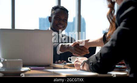 Primo piano scuotimento mani di uomo d'affari africano con donne caucasiche. Concetto di lavoro di squadra per la diversità. Foto Stock