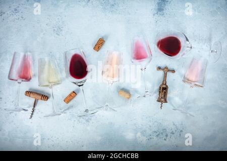 Sfondo del vino con bicchieri di vino rosato, rosso e bianco, con tappi e tappi, foto a sovrapposizione piatta con spazio per la copia. Vari colori Foto Stock