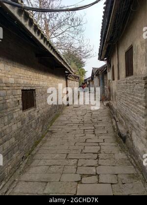 Un antico vicolo con una strada di pietra di ciottoli e vecchie mura in gesso casa nel bellissimo antico Lizhuang Foto Stock