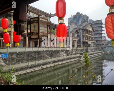 Splendida vista degli edifici lungo il fiume che attraversa il quartiere di Nanxi di Yibin City a Sichuan, che include una pagoda, un hotel e ristoranti Foto Stock