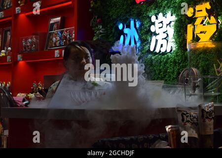 Una tazza di bere con nube come vapore da ghiaccio secco che lo fa fumare servito in una strada popolare a Chengdu chiamato Kuanzhai Xiangzi Foto Stock