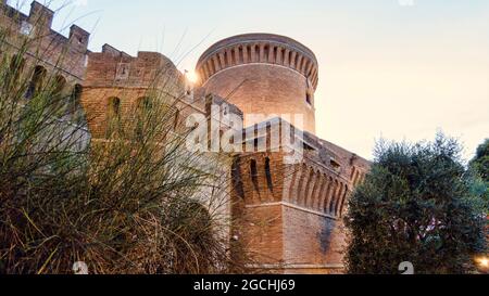 Suggestivo scorcio al tramonto presso il fantastico castello di Giulio II a Ostia Antica, Roma, la sua antica architettura romana perfettamente conservata Foto Stock