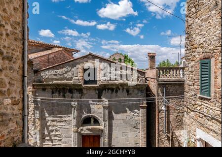 La facciata dell'antica Chiesa di San Bernardino nel centro storico di Passignano sul Trasimeno, in Italia, contro un bel cielo Foto Stock