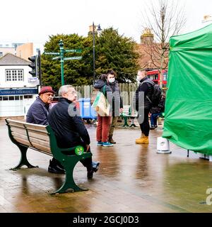 Dicembre 2020, Epsom Surrey, Londra Regno Unito, due uomini di età media seduti su un panca che parla Foto Stock