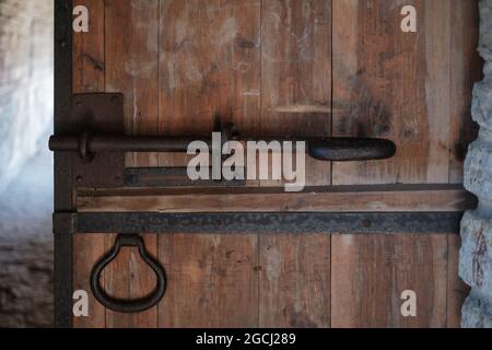 Una vecchia porta con una serratura di ferro arrugginita. Foto Stock