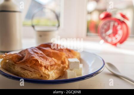 Torta al formaggio al forno con latte. Banitsa di burro bulgaro per colazione Foto Stock