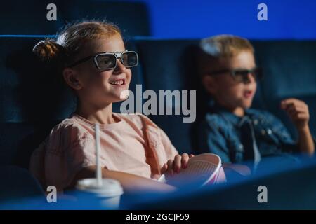Bambini piccoli con occhiali 3d al cinema, guardando film. Foto Stock