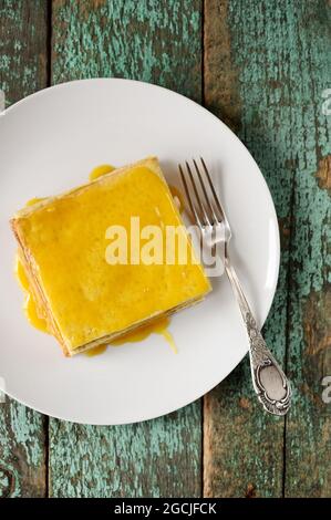 Vista dall'alto imperfetta torta al limone quadrata e forchetta su piastra bianca Foto Stock