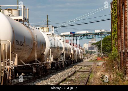 Detroit, Michigan - Tank auto chimiche Railroad vicino al centro di Detroit. Sopra i binari, i camion sul ponte Ambassador dirigono verso il Canada. Foto Stock