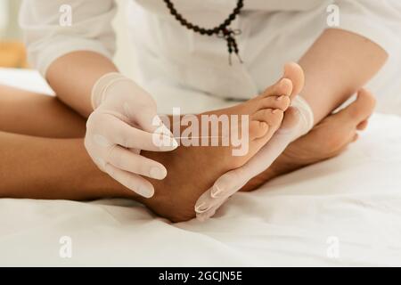 Chiropractor che fa la terapia di agopuntura per i piedi femminili con gli aghi. Trattamento dell'agopuntura per il dolore cronico del piede Foto Stock