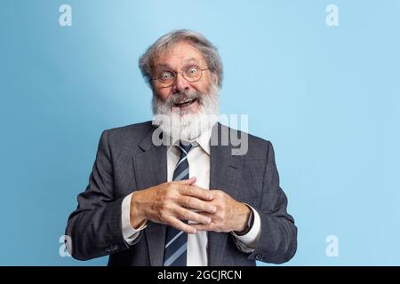 Professore pazzo, insegnante, uomo bearded grigio-testa che posa isolato su sfondo grigio studio. Concetto di occupazione professionale, lavoro, istruzione, divertente Foto Stock