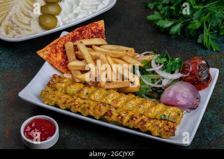 Kebab di tikka di pollo serviti su spiedini con salsa alla menta o chutney Foto Stock