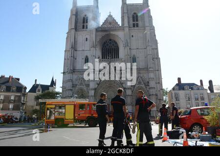 File photo datato 18 luglio 2020 - UN ufficiale di polizia francese gesti come vigili del fuoco sono al lavoro per spegnere un incendio alla cattedrale di Saint-Pierre-et-Saint-Paul a Nantes, Francia occidentale, il 18 luglio 2020. Il grande incendio scoppiato il 18 luglio 2020 all'interno della cattedrale nella città francese occidentale di Nantes è stato ora contenuto, i servizi di emergenza ha detto. "Si tratta di un grande incendio", ha detto il centro operativo di emergenza, aggiungendo che gli equipaggi sono stati avvisati poco prima delle 08:00 (0600 GMT) e che sono stati inviati 60 vigili del fuoco. -- UN cittadino ruandese sospettato di causare un incendio importante che ha devastato il gatto Foto Stock