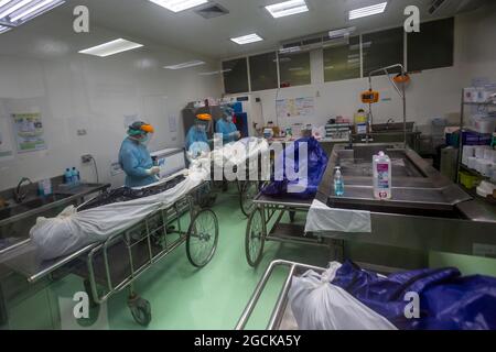 Khlong Luang, Pathum Thani, Thailandia. 9 agosto 2021. Un medico presso il Dipartimento di Scienze Forensice dell'Università di Thammasart Rangsit Campus Hospital esegue un test con tampone nasale COVID - 19 sul cadavere. (Credit Image: © Aldryel Talamantes/ZUMA Press Wire) Foto Stock