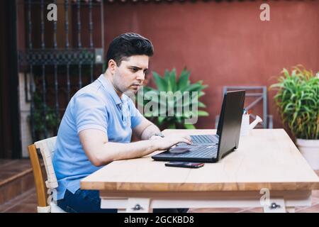 Uomo su una terrazza che commercia criptovalute Foto Stock