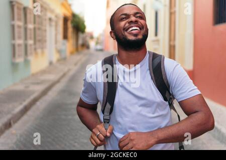Giovane uomo afro-americano che porta lo zaino mentre si trova all'aperto Foto Stock